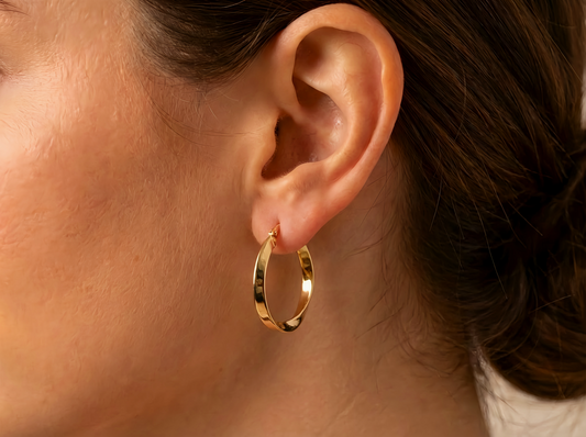 Gedraaide hoepel oorbellen 23 mm 14k goud, gedragen in het oor