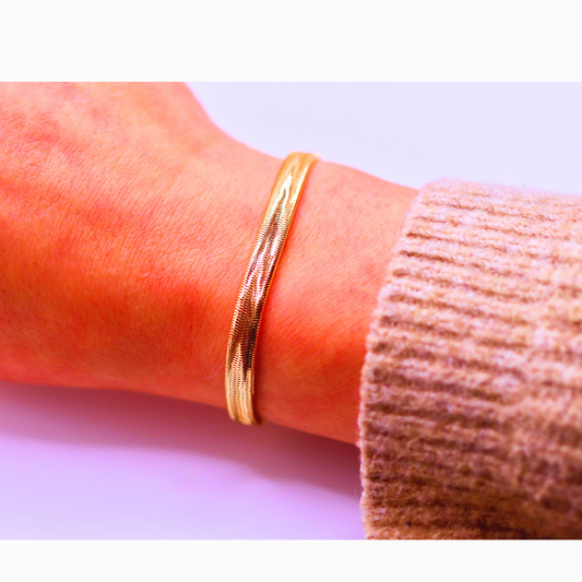 Geweven stretch armband 5,5 mm 14k goud, gedragen om de pols