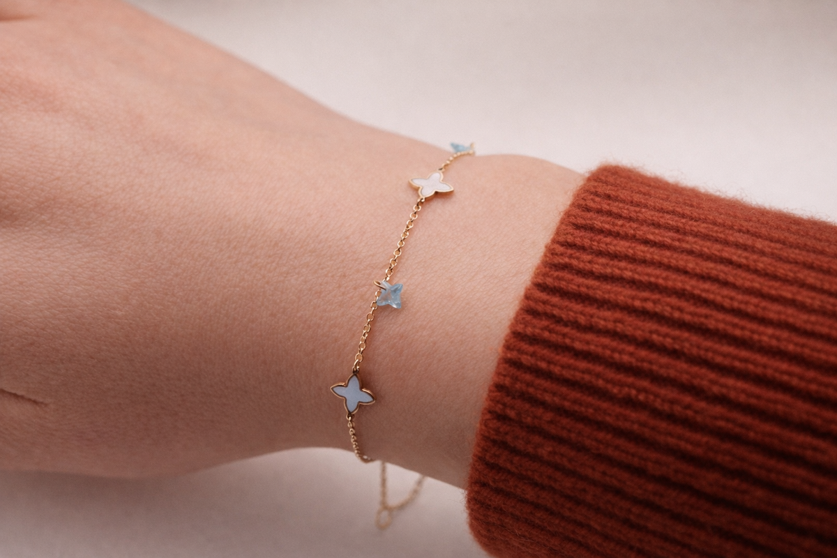 Klaver armband parelmoer & blauw detail 1 mm 9k goud, gedragen om de pols