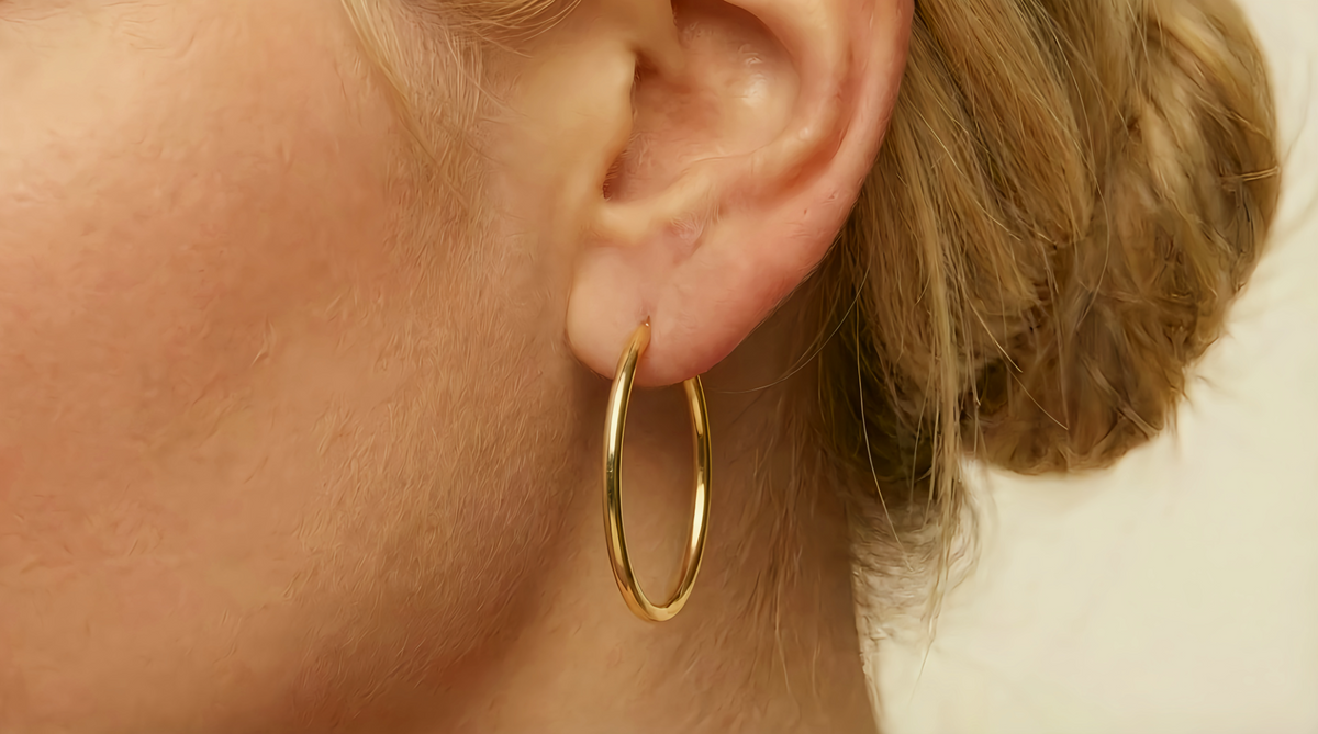 Ovale creolen 33 mm 14k goud, gedragen in het oor