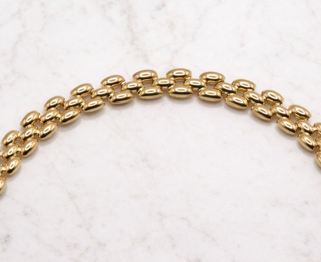 Panter armband 8,5 mm 14k goud, close-up van de schakels op natuursteen