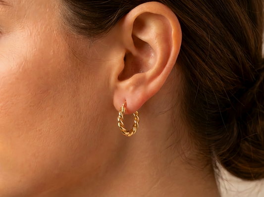 Gevlochten creolen 18 mm 14k goud, gedragen in het oor