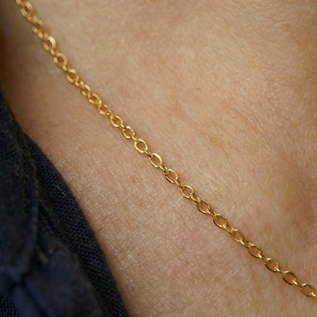 Anker schakelketting 0,6 mm 14k goud, close-up gedragen om de hals