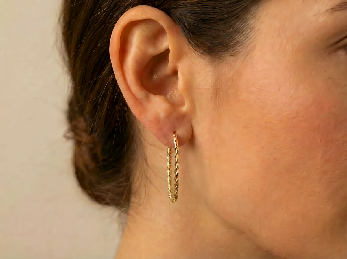 Gedraaide rechthoekcreolen 30 mm 14k goud, gedragen in het oor