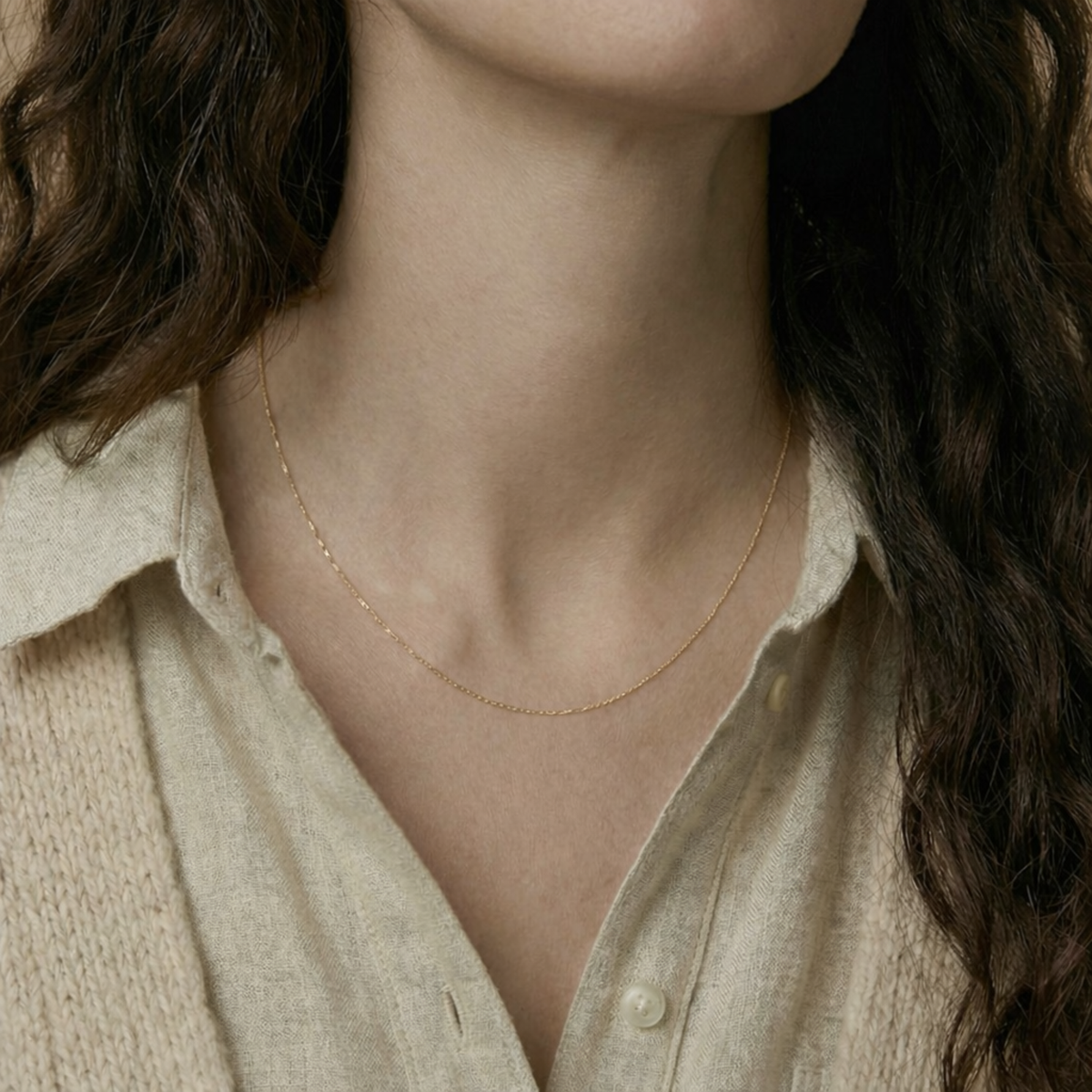 Kabel schakelketting 0,75 mm 14k goud, gedragen om de hals door een model