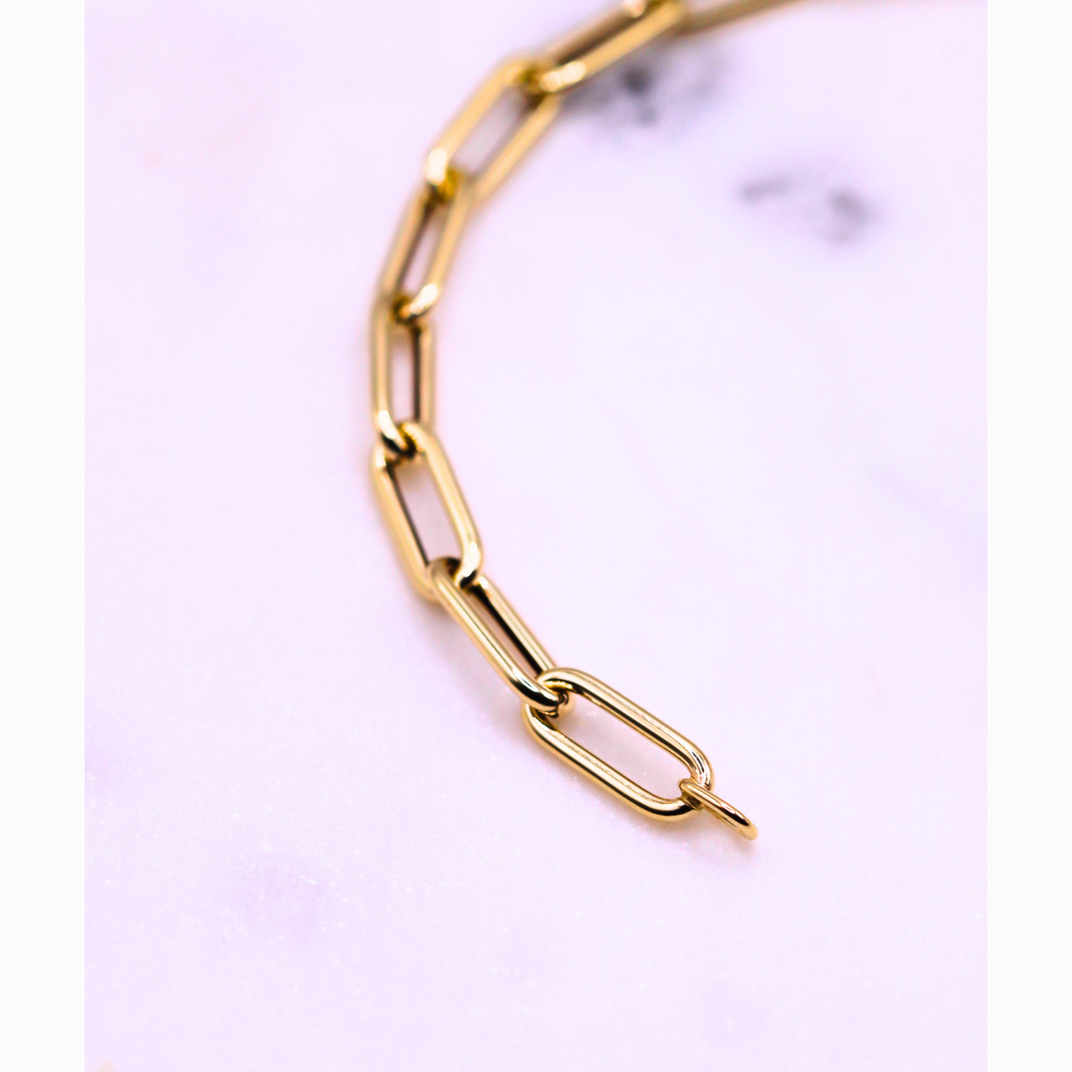 Paperclip armband 5 mm 14k goud, gebogen close-up van de schakels