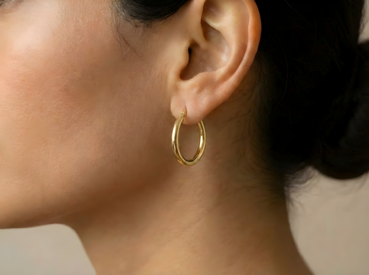 Platte creolen 24 mm 14k goud, gedragen in het oor