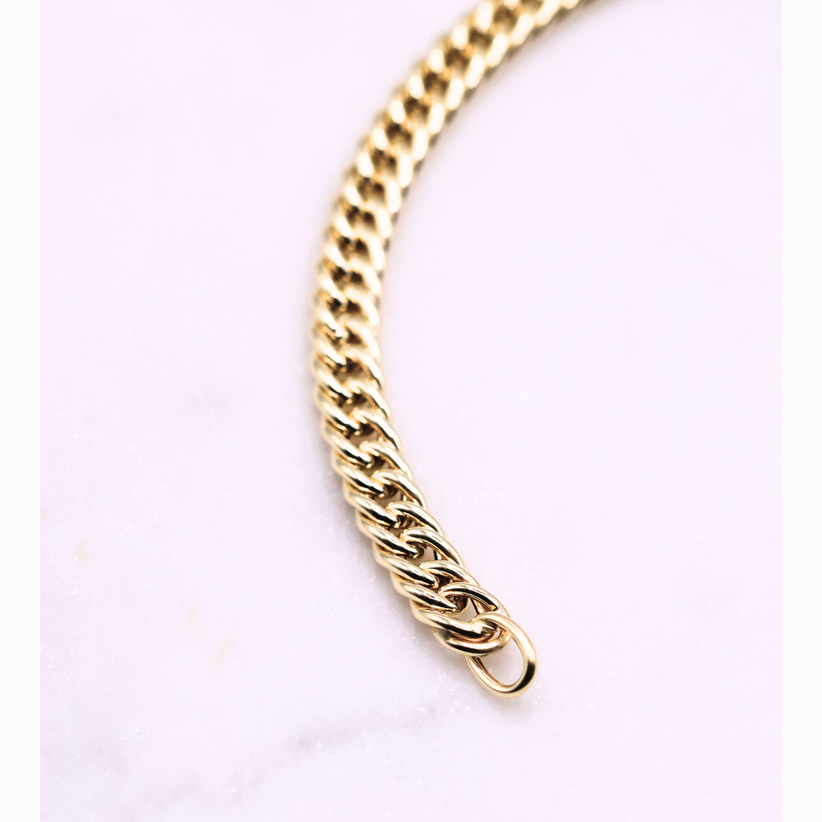 Gourmet armband dubbel 5 mm 14k goud, S-vormig opengelegd op natuursteen
