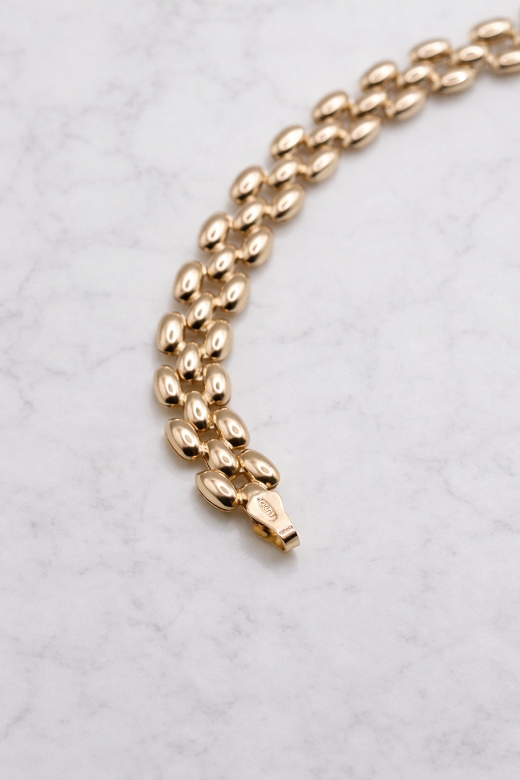 Panter armband 8,5 mm 14k goud, S-vormig opengelegd op natuursteen