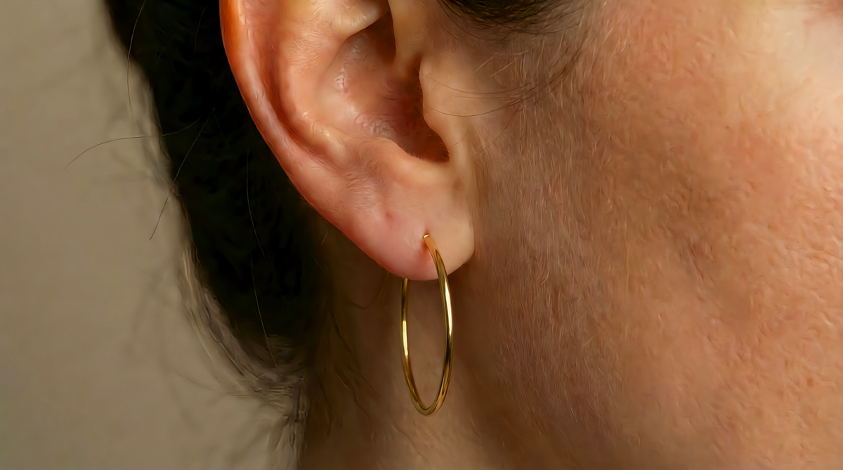 Slanke creolen 30 mm 14k goud, gedragen in het oor