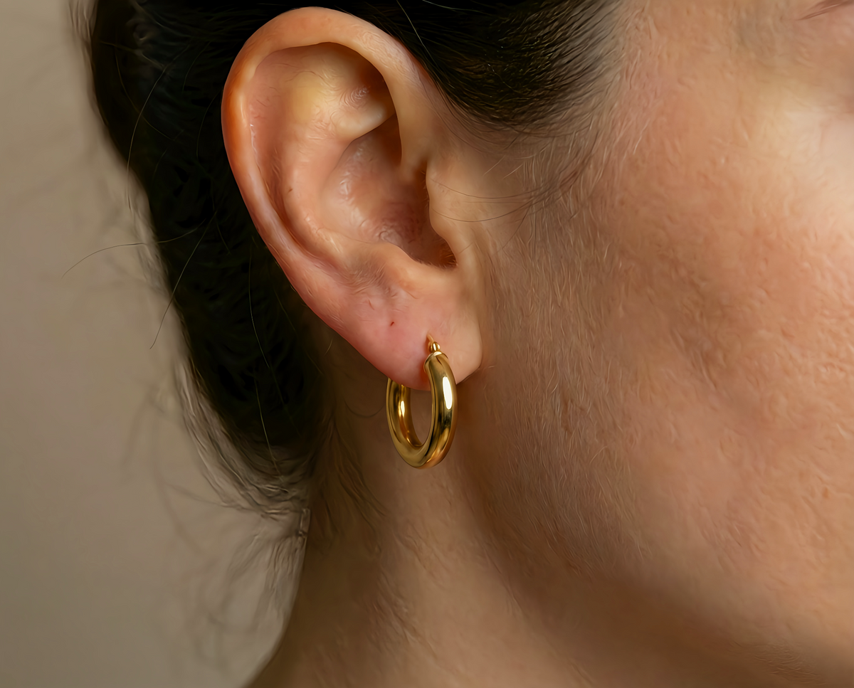 Gladde creolen 16 mm 14k goud, gedragen in het oor