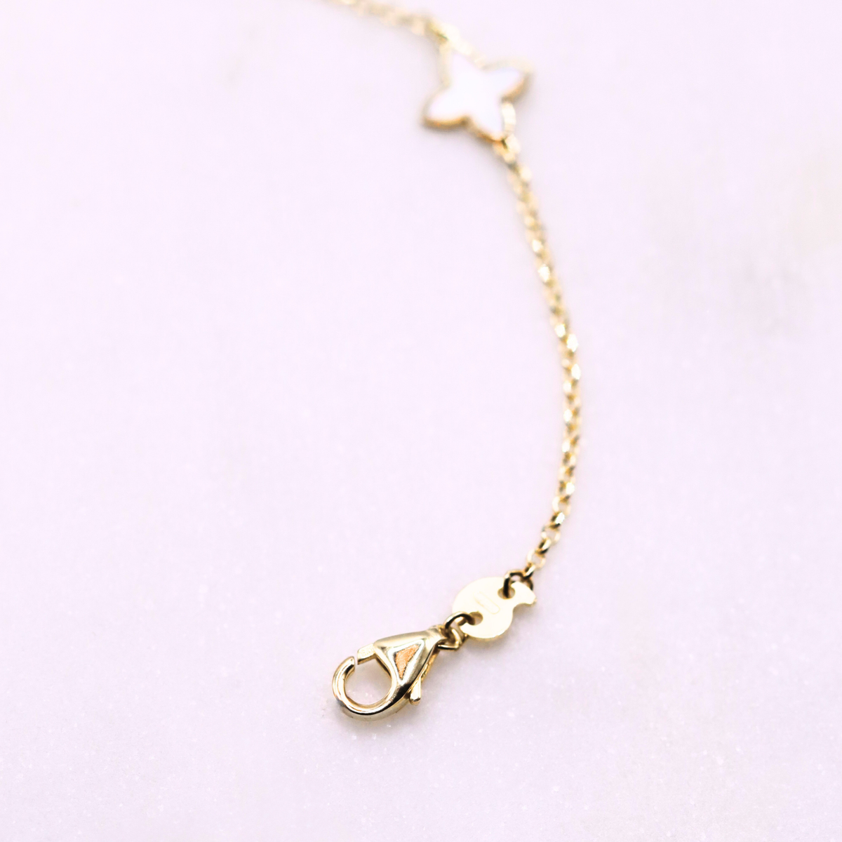 Klaver armband parelmoer & blauw detail 1 mm 9k goud, detail van de karabijnsluiting