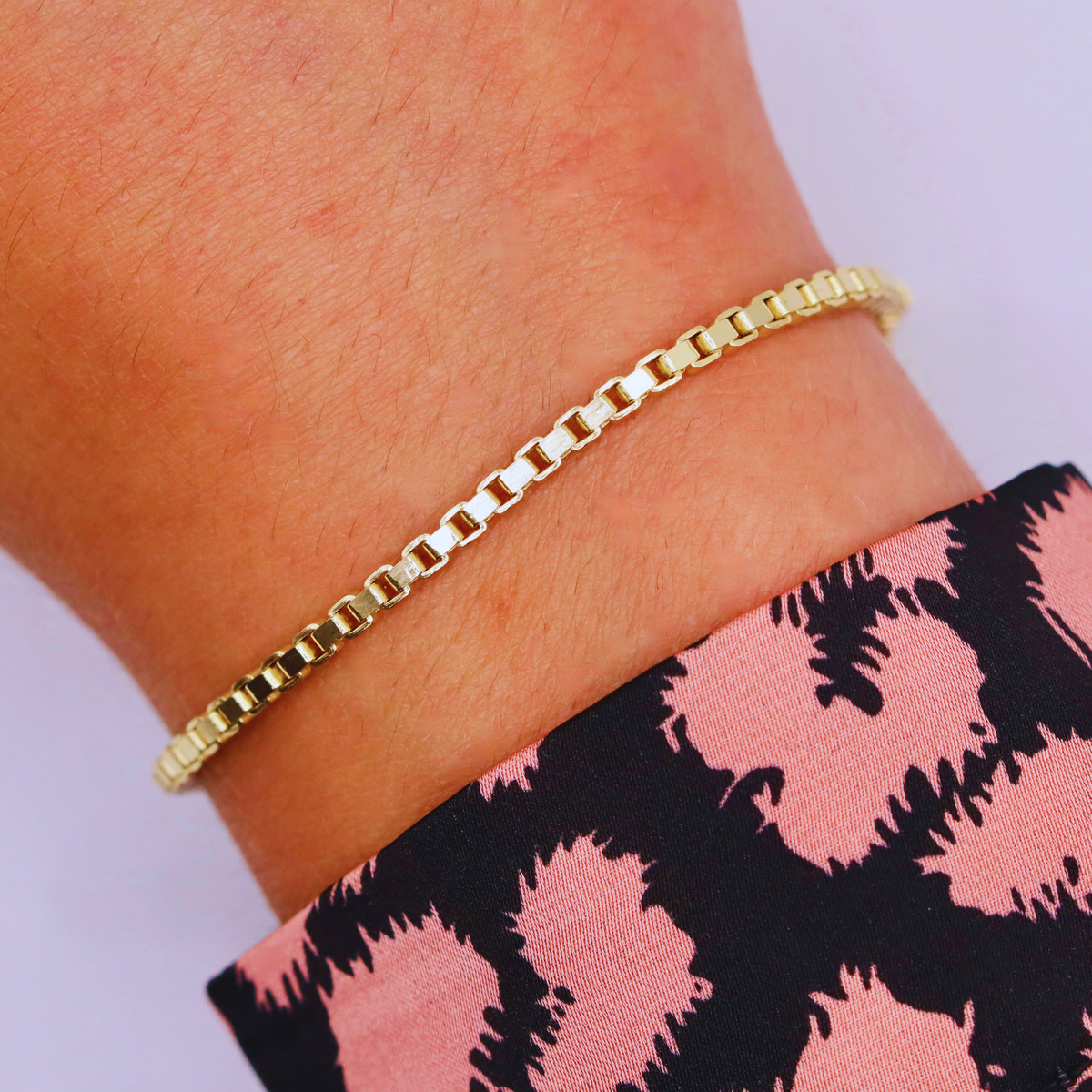 Box schakelarmband 2,75 mm 14k goud, gedragen om de pols