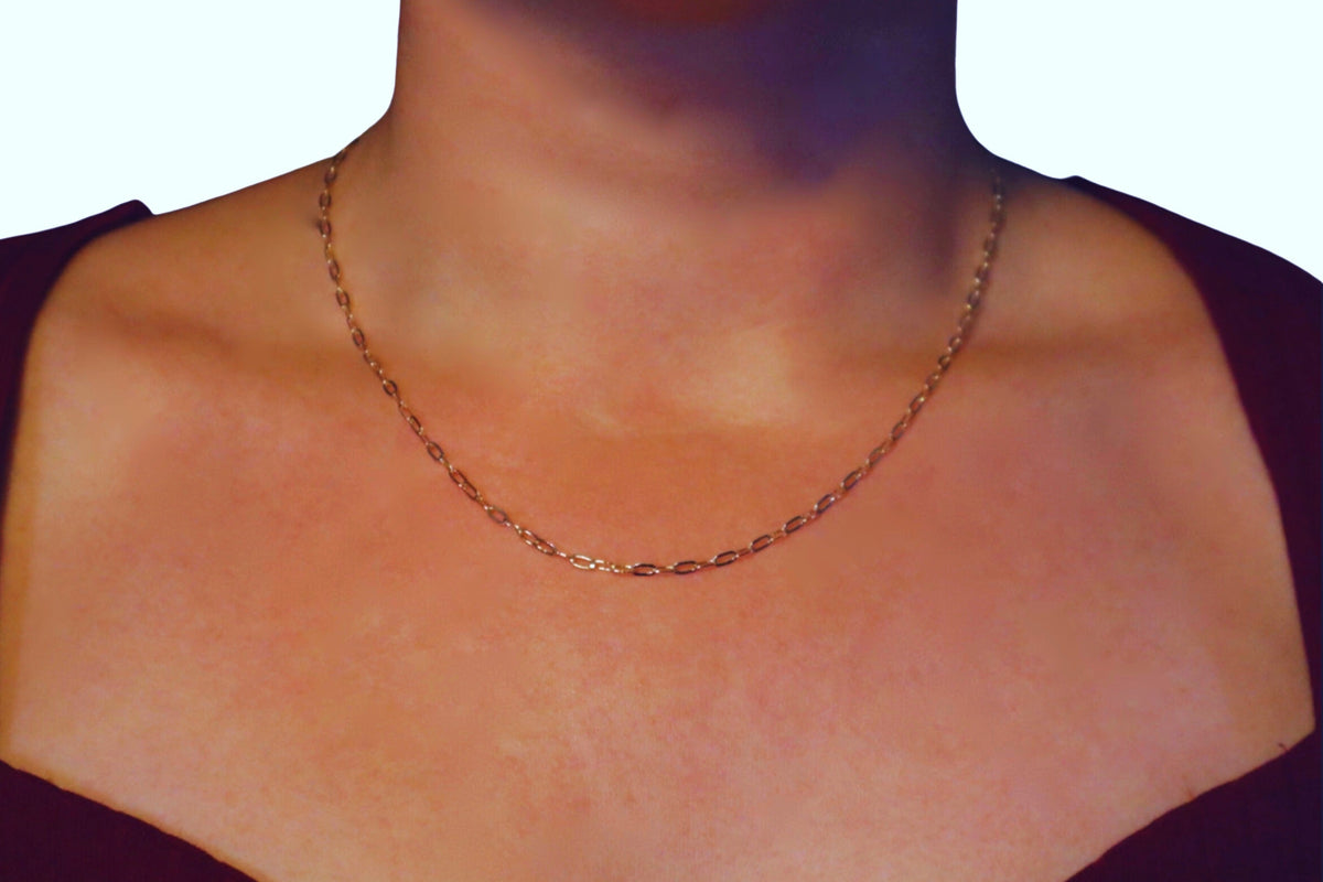 Ovale Schakelketting 2,5 mm 14k goud, gedragen om de hals door een model