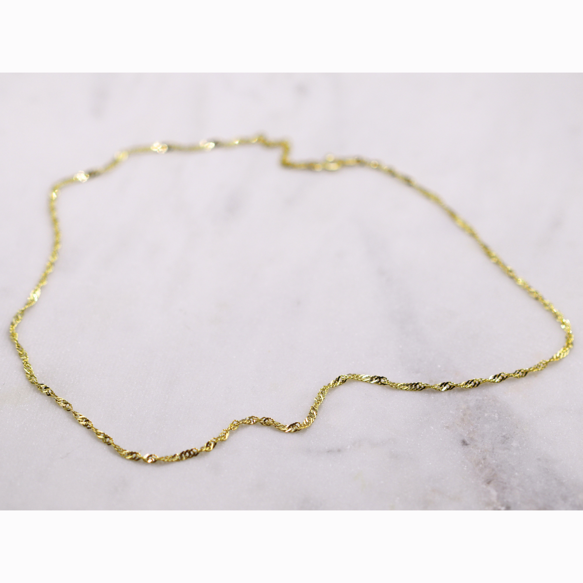 Twist ketting 2,25 mm 14k goud, opengelegd op natuursteen
