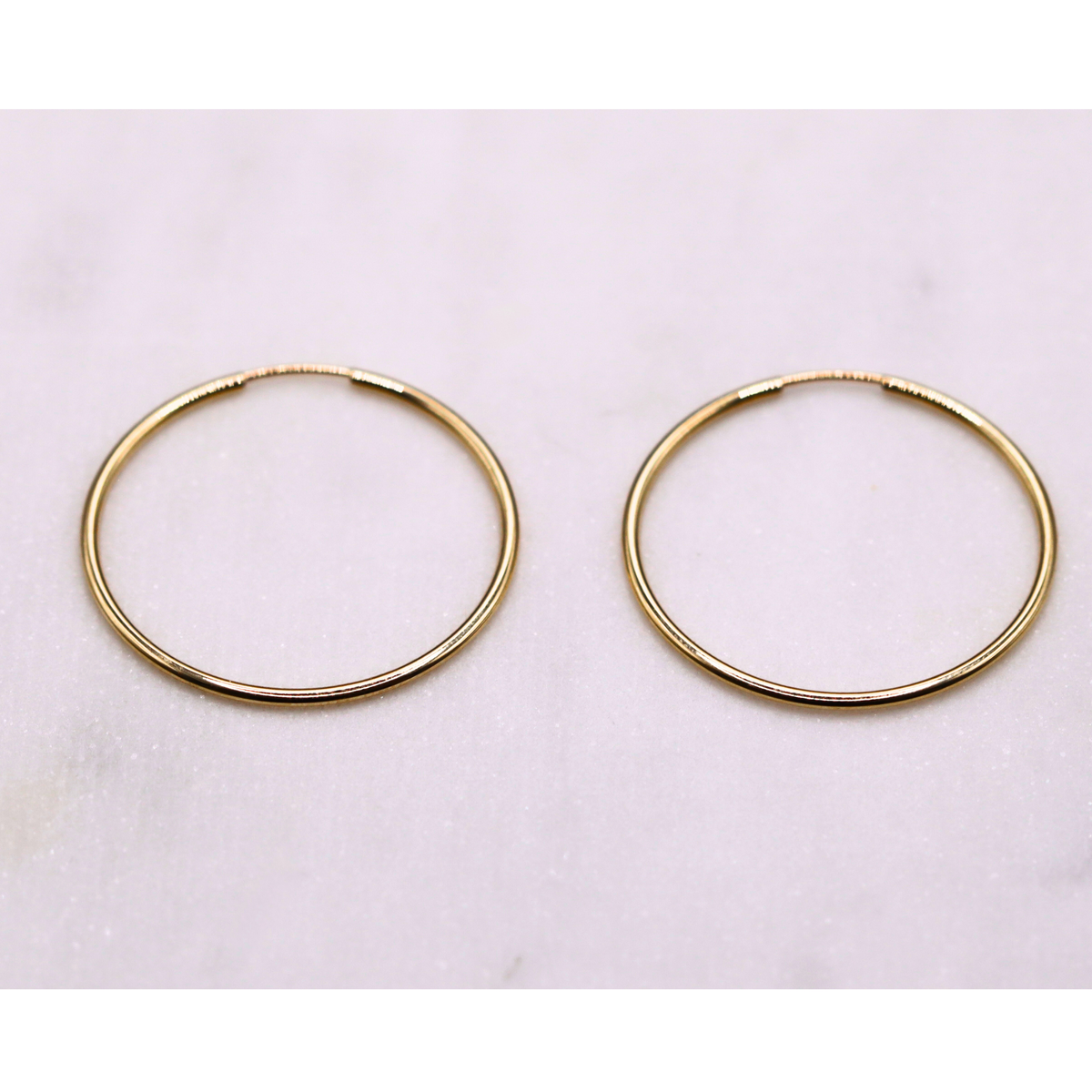 Slanke creolen 30 mm 14k goud, paar op natuursteen
