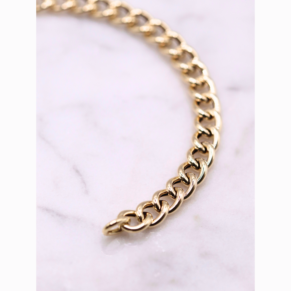 Gourmet armband statement 5,75 mm 14k goud, close-up van de schakels op natuursteen