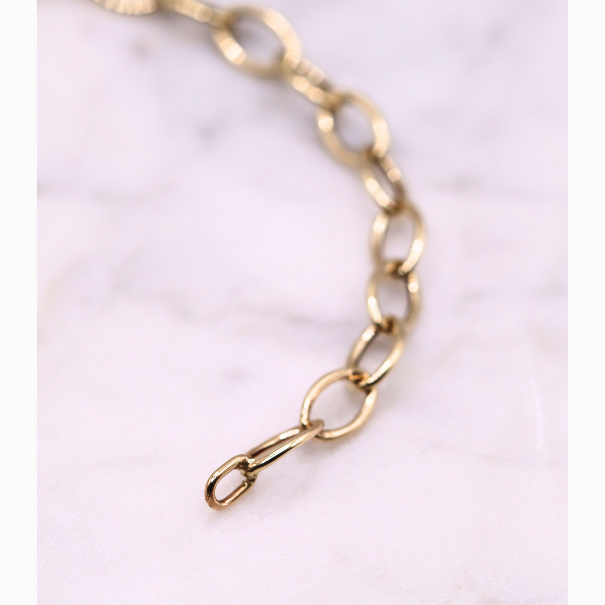 Ovale schakelarmband 5,5 mm 14k goud, gebogen close-up van de schakels