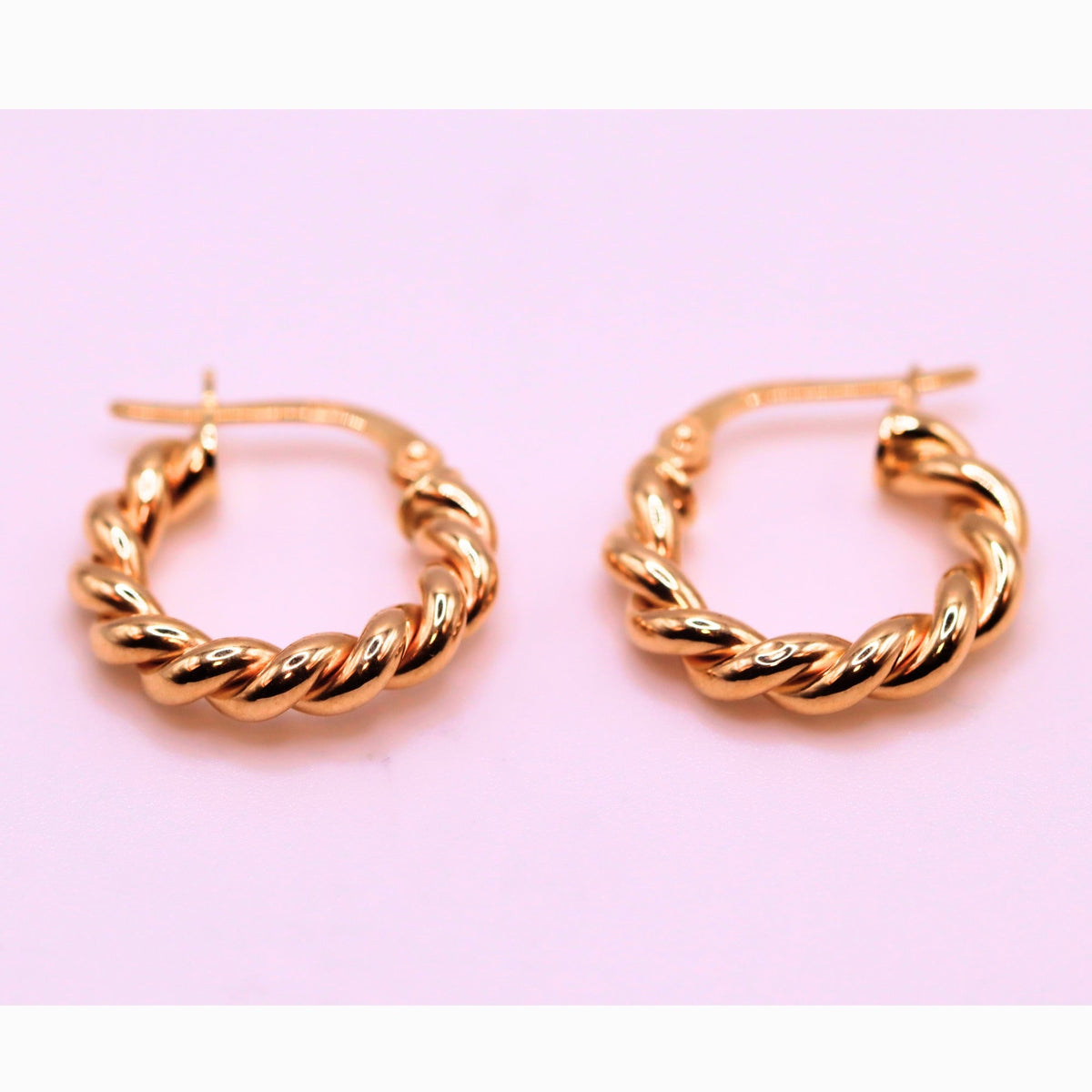 Gevlochten creolen 18 mm 14k goud, paar op lila achtergrond