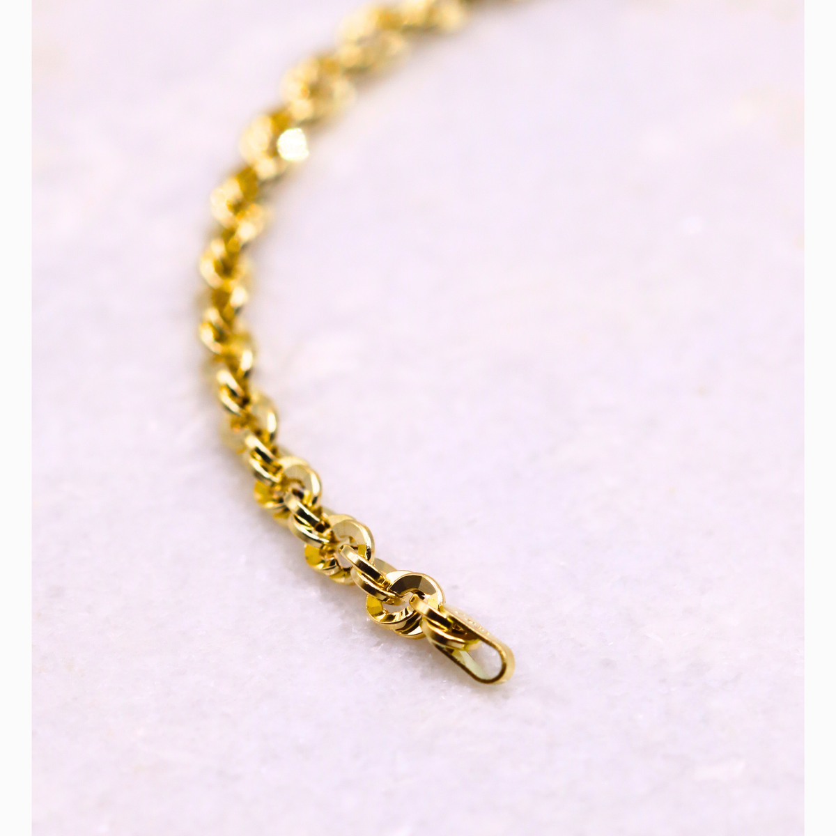Gedraaide Schakelarmband 4 mm 14k goud, close-up van het eindstuk