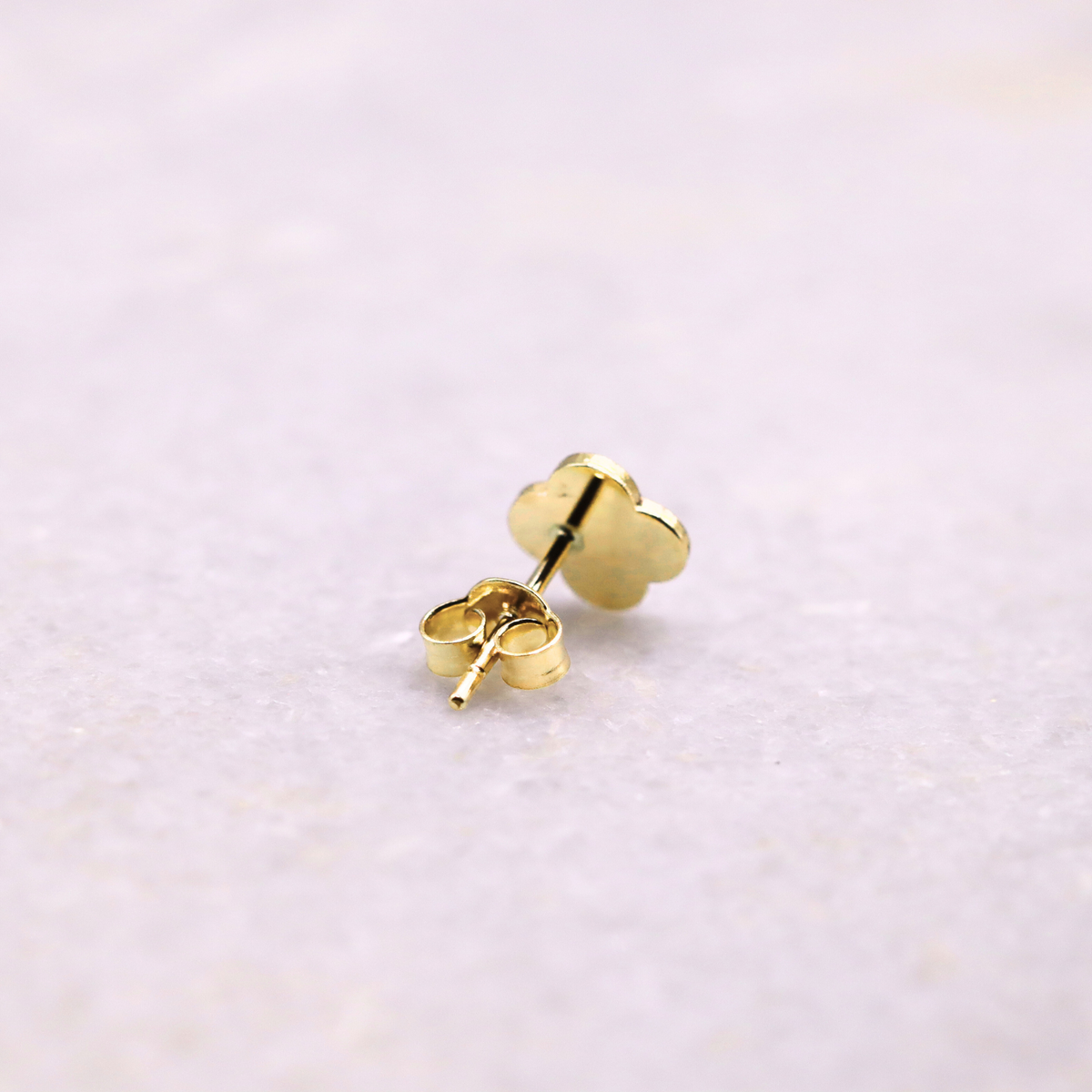 Klaver oorstekers parelmoer 14k goud, close-up op natuursteen