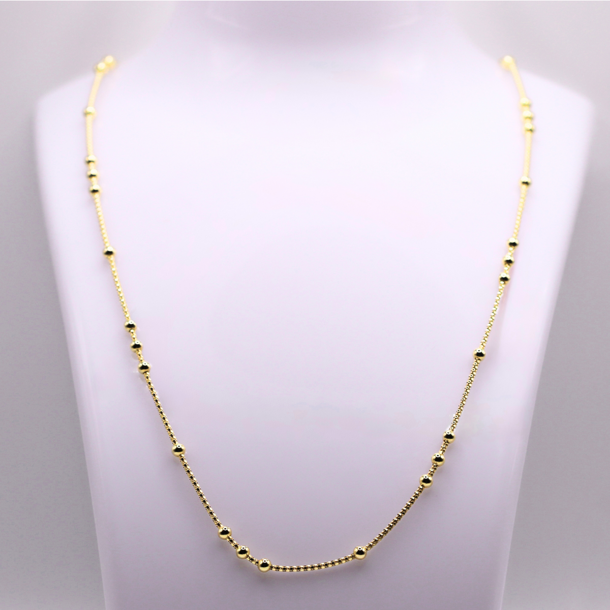 Bolletjes station ketting 3 mm 14k goud op een sieradenbuste