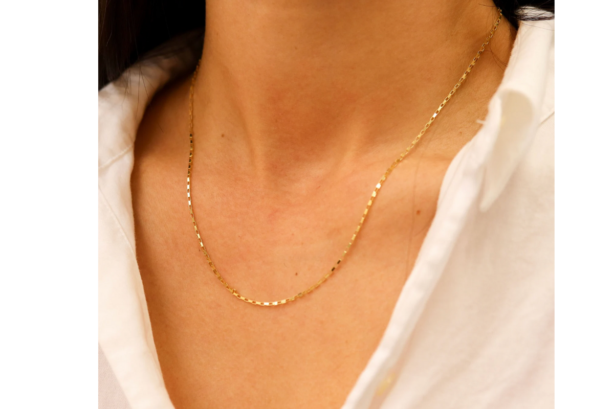 Boxketting 1,25 mm 14k goud, gedragen om de hals door een model