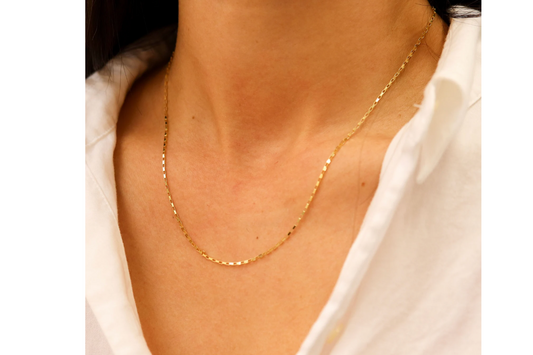 Boxketting 1,25 mm 14k goud, gedragen om de hals door een model