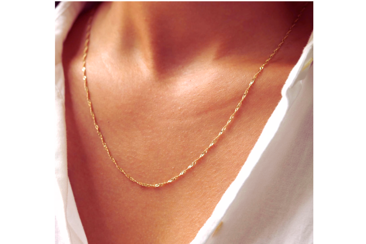 Twist ketting 2,25 mm 14k goud, gedragen om de hals door een model