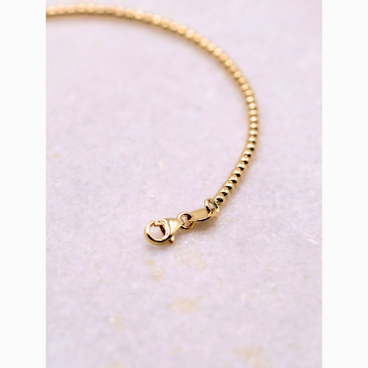 Bolletjes armband 2 mm 14k goud, detail van de karabijnsluiting