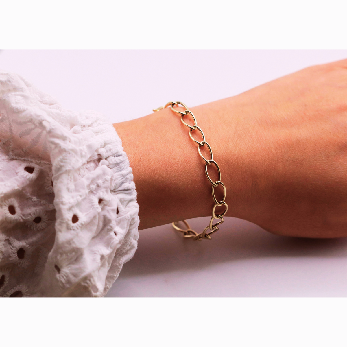 Ovale schakelarmband 6,5 mm 14k goud, gedragen om de pols