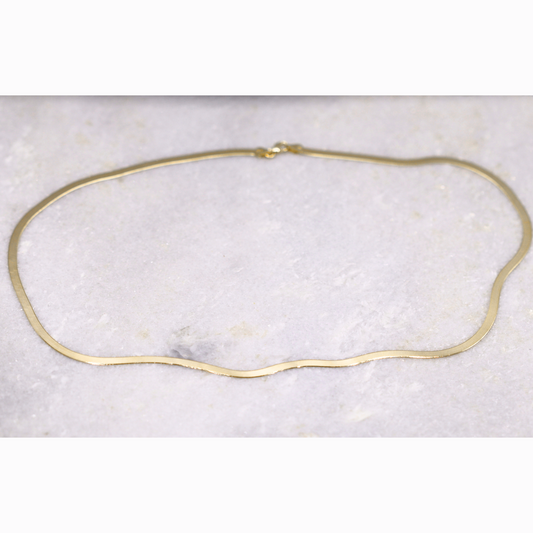 Herringbone ketting 3 mm 14k goud, opengelegd op natuursteen