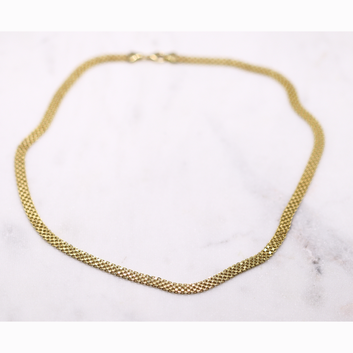 Bismarck ketting 5,5 mm 14k goud, opengelegd op natuursteen