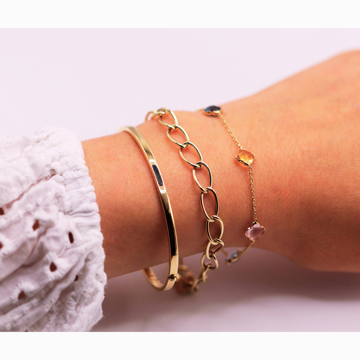 Ovale schakelarmband 6,5 mm 14k goud, gedragen in een armbandenset om de pols