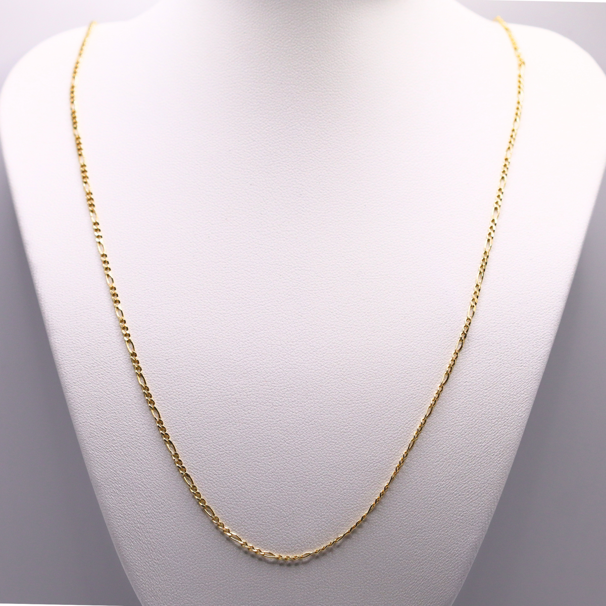 Figaro schakelketting 2 mm 14k goud op een sieradenbuste