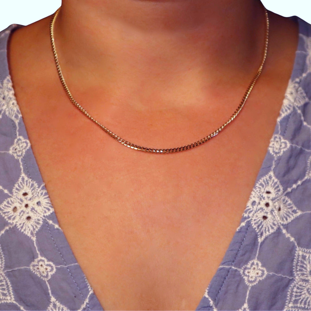 Gourmet ketting 2,5 mm 14k goud, gedragen om de hals door een model