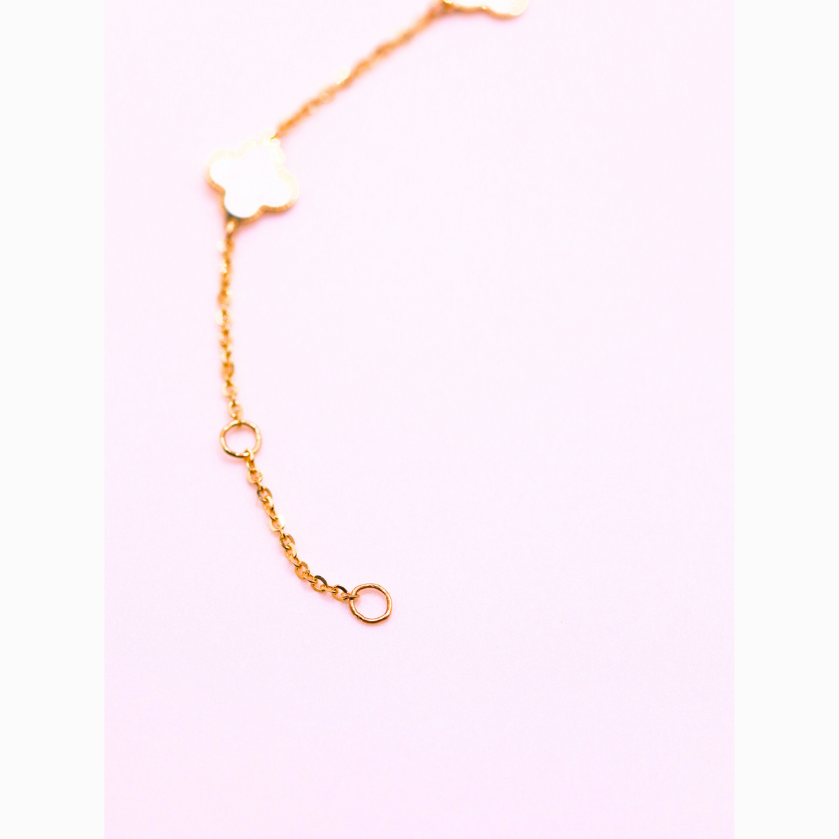 Klaver armband parelmoer detail 1 mm 14k goud, S-vormig opengelegd op natuursteen