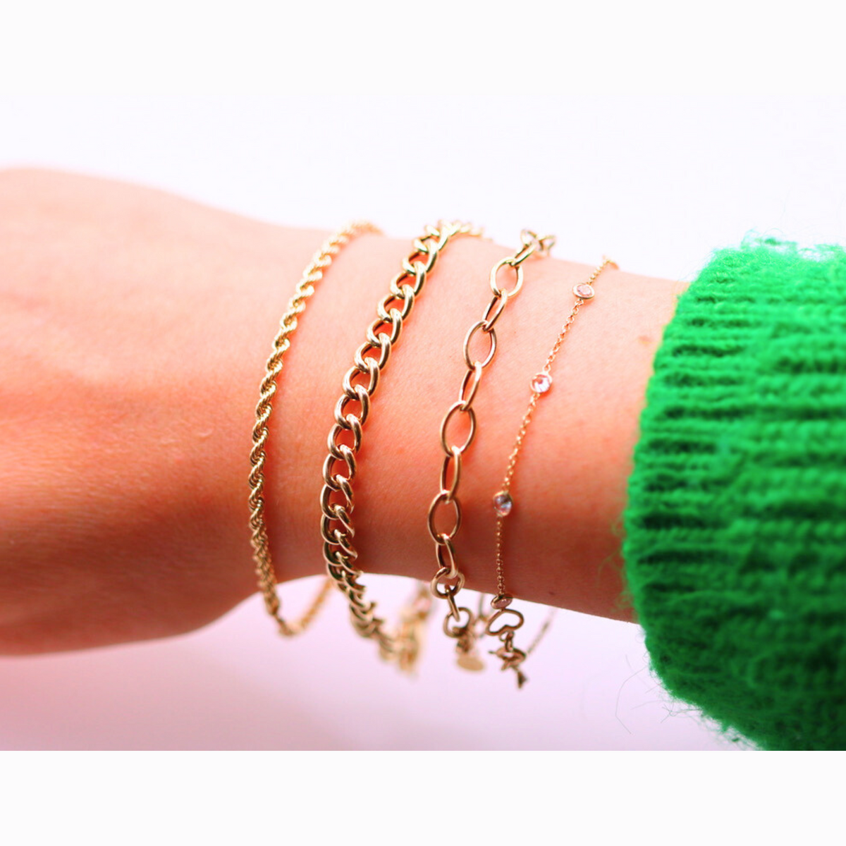 Ovale schakelarmband 5,5 mm 14k goud, gedragen in een armbandenset om de pols
