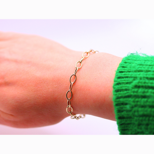 Ovale schakelarmband 5,5 mm 14k goud, gedragen om de pols