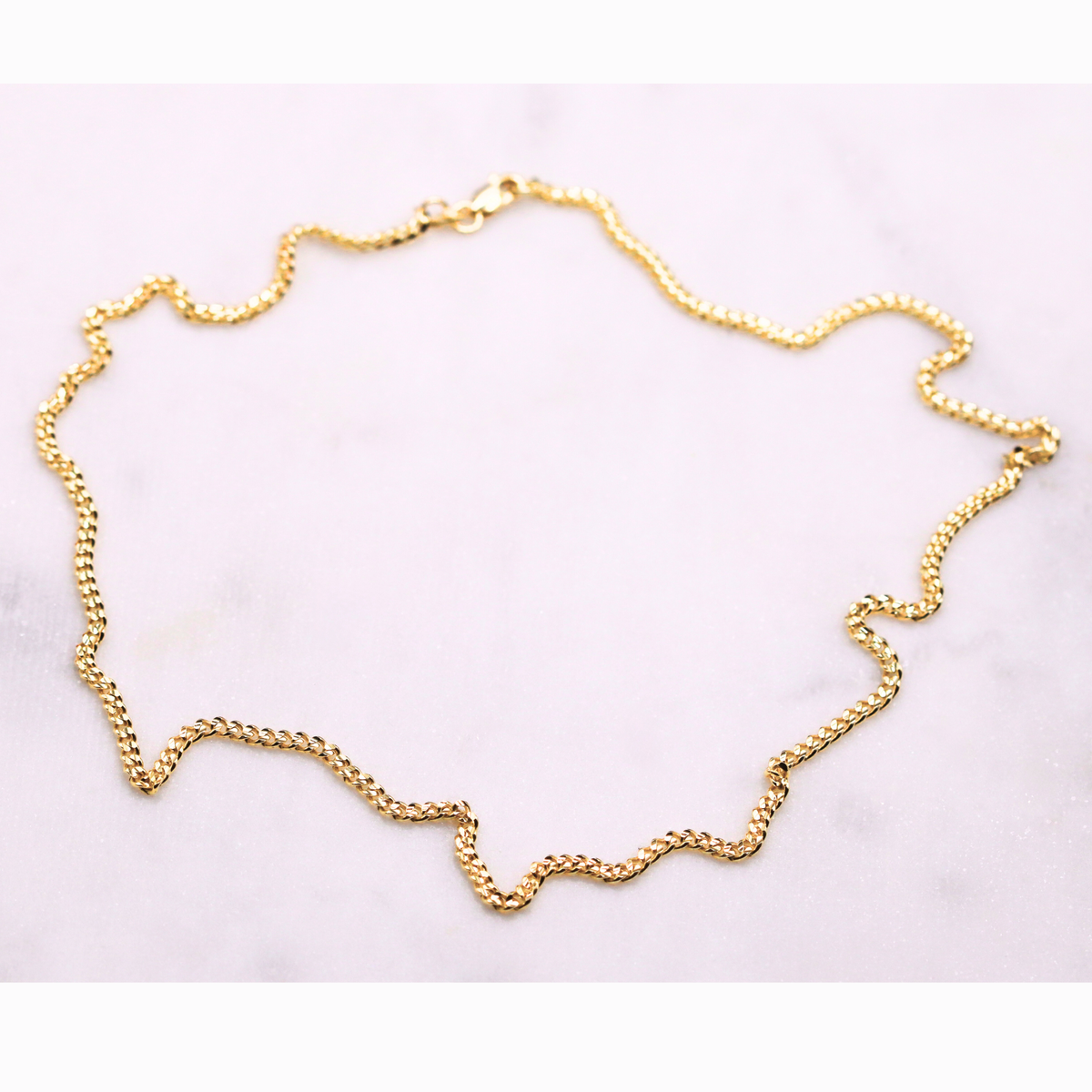 Gourmet ketting 2,5 mm 14k goud, opengelegd op natuursteen