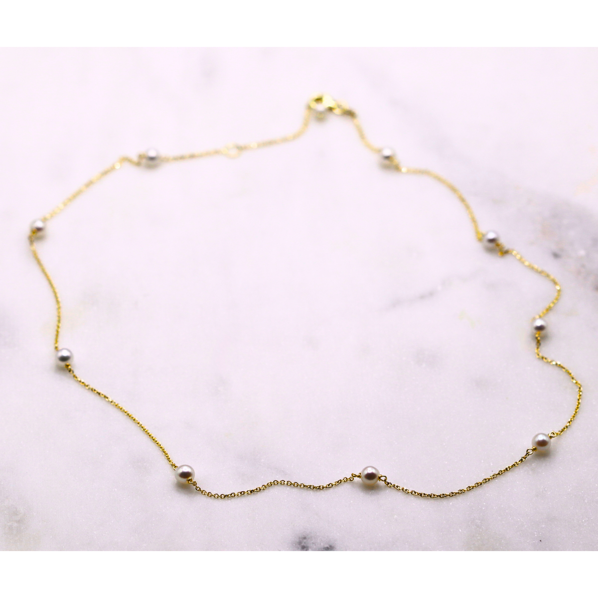 Parel ketting 14k goud, opengelegd op natuursteen