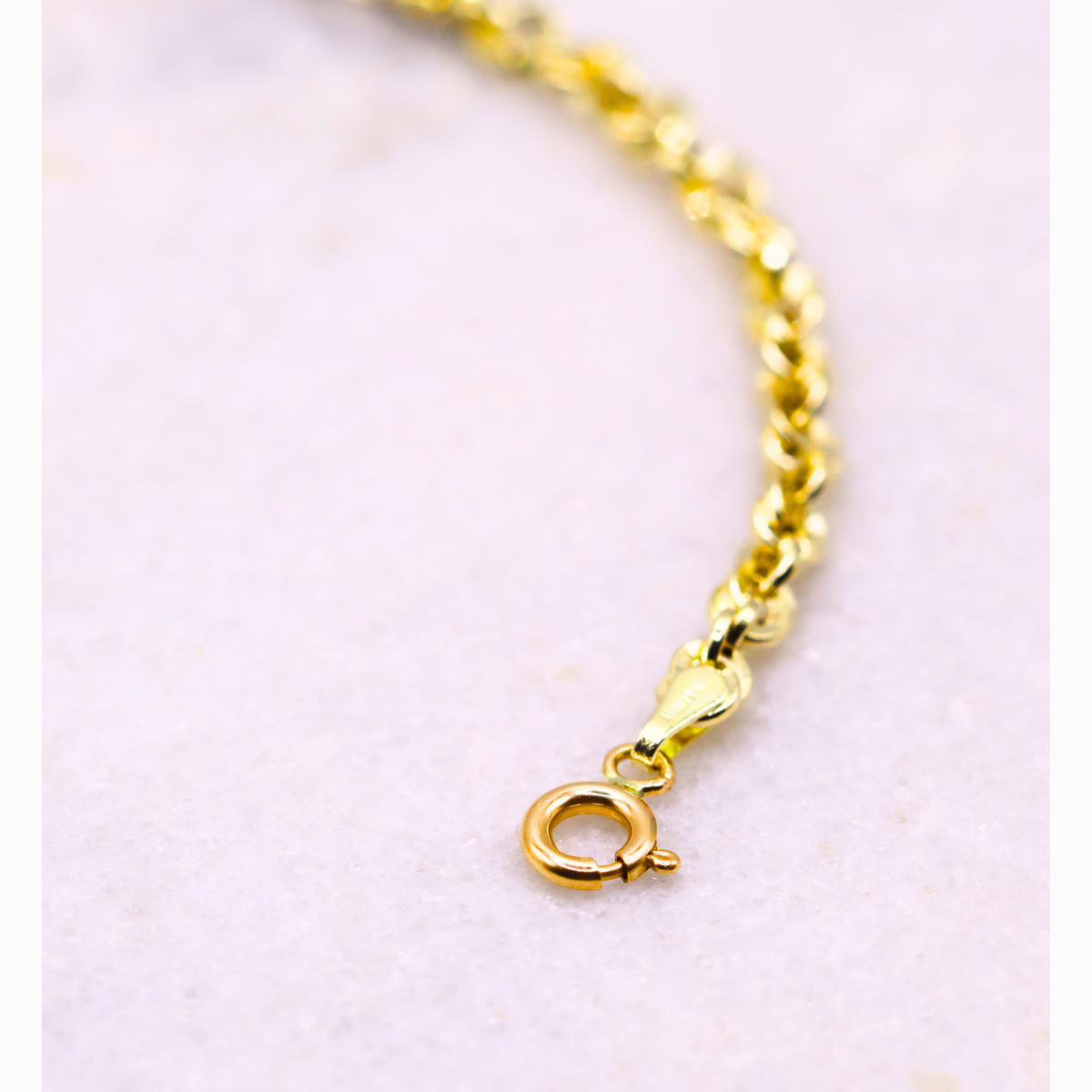 Gedraaide Schakelarmband 4 mm 14k goud, close-up van de veerringsluiting