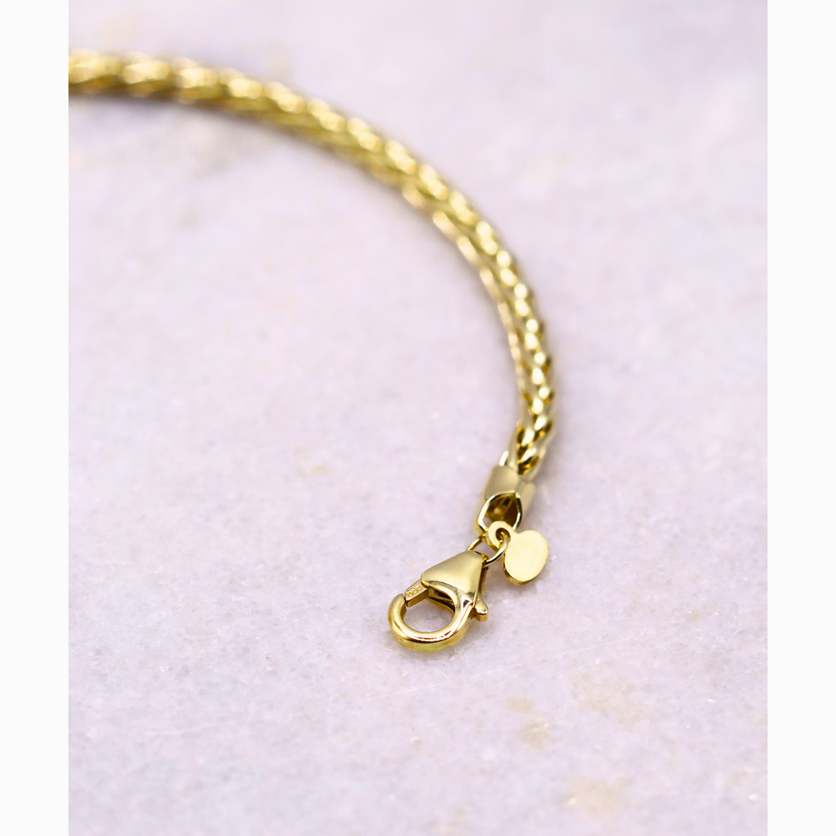 Gevlochten Vossenstaart armband 3 mm 14k goud, detail van de karabijnsluiting