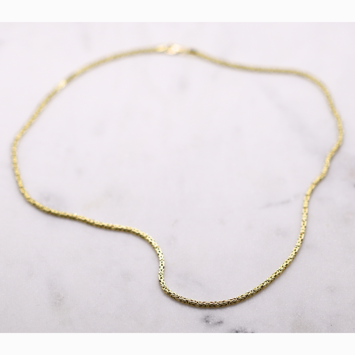 Byzantijnse ketting 2 mm 14k goud, opengelegd op natuursteen