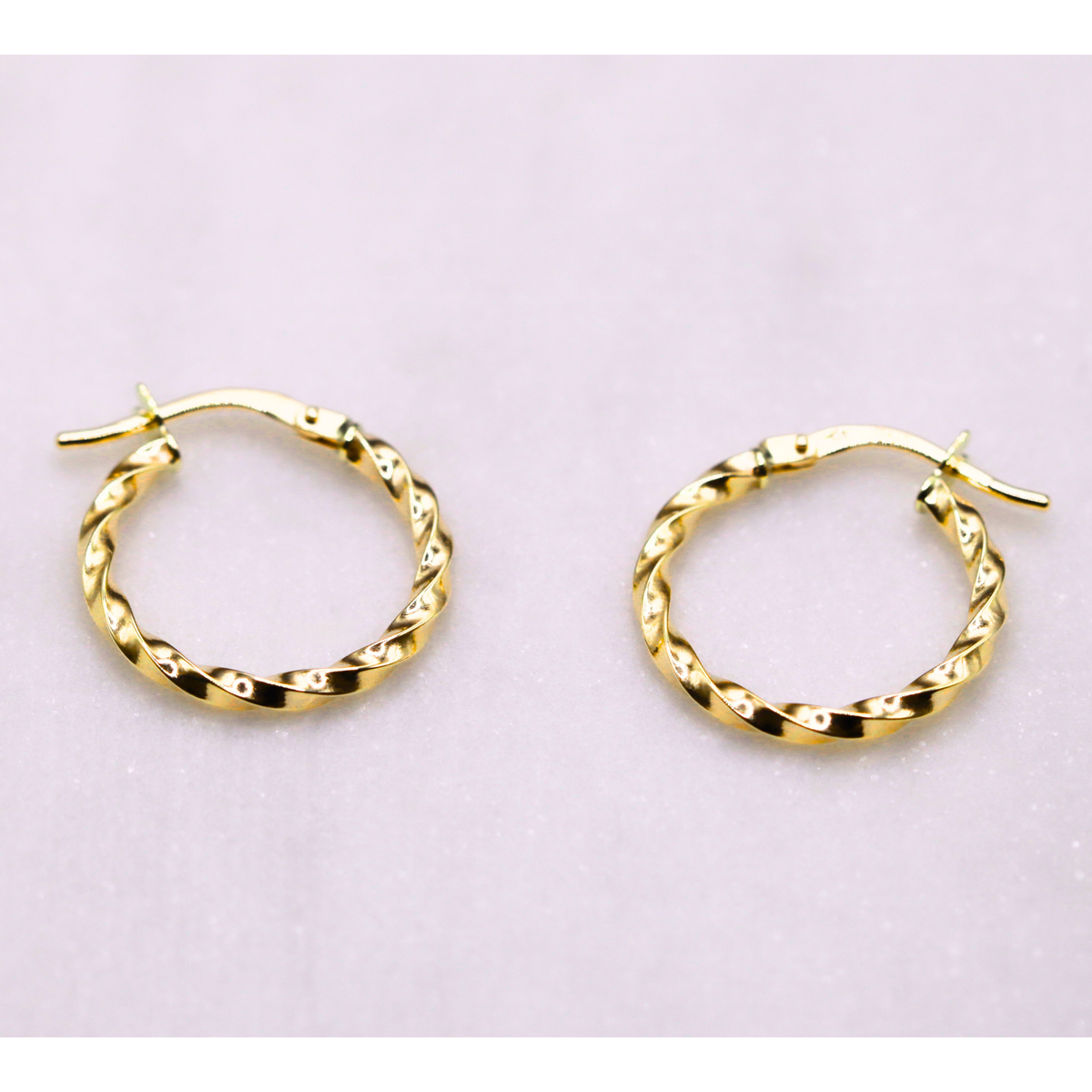 Gedraaide vlechtcreolen 17 mm 14k goud, paar op natuursteen