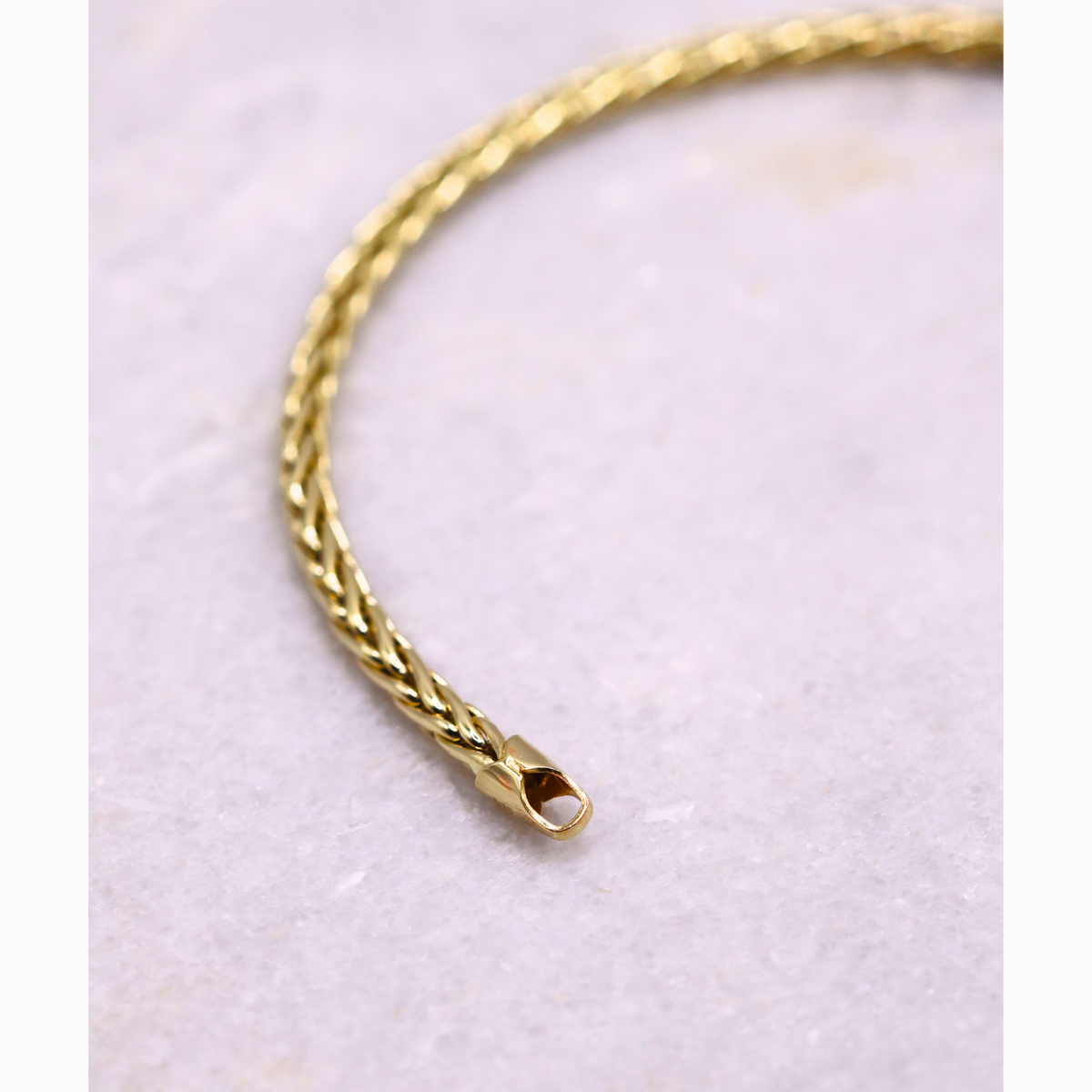 Gevlochten Vossenstaart armband 3 mm 14k goud, gebogen close-up van de schakels