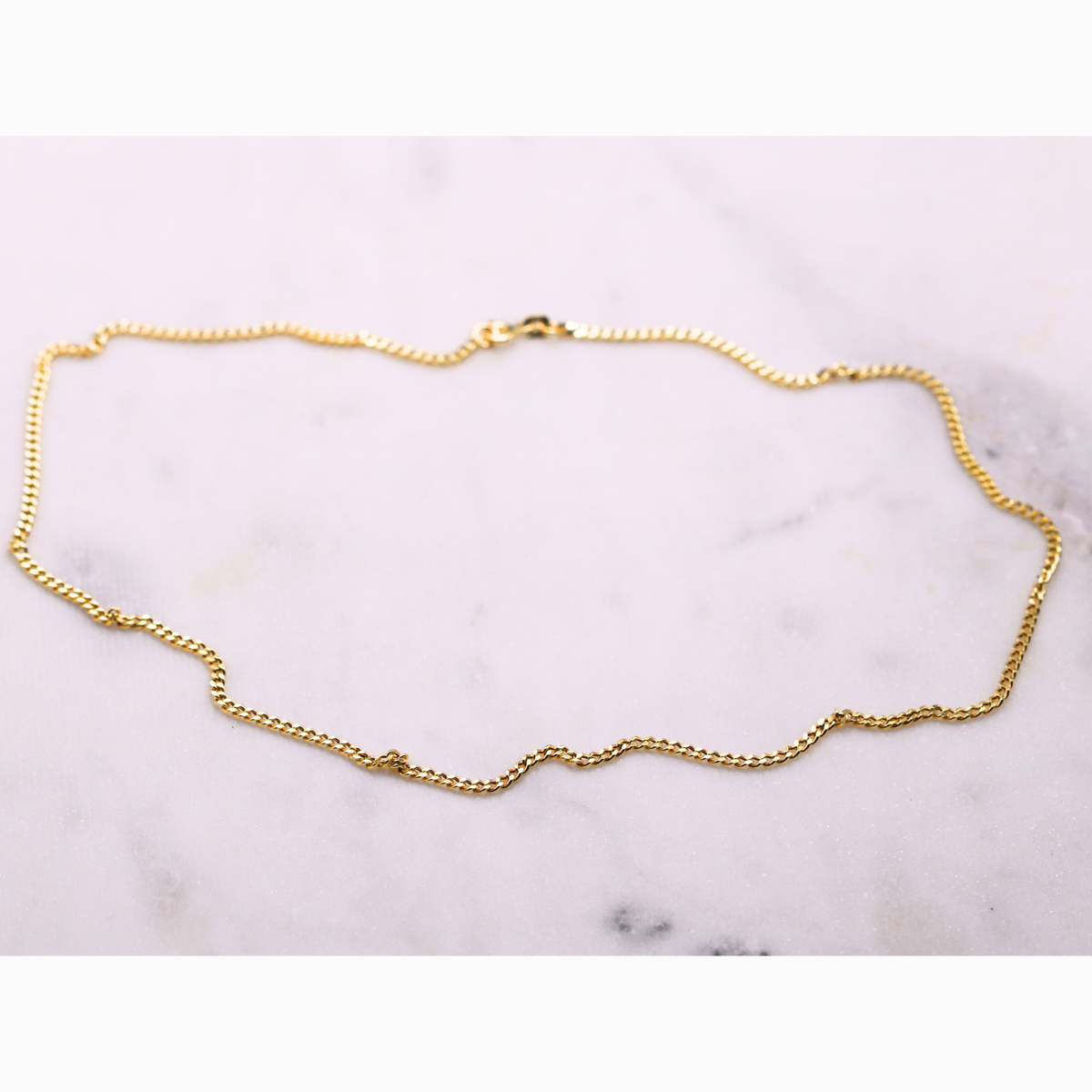 Gourmet ketting 2,5 mm 14k goud, opengelegd op natuursteen