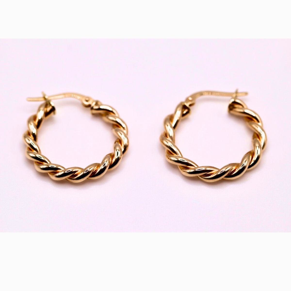 Gedraaide oorringen 22 mm 14k goud, paar op lila achtergrond