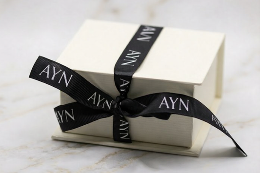 AYN Edition cadeaubox: crème juwelendoosje met zwart AYN-signatuurlint