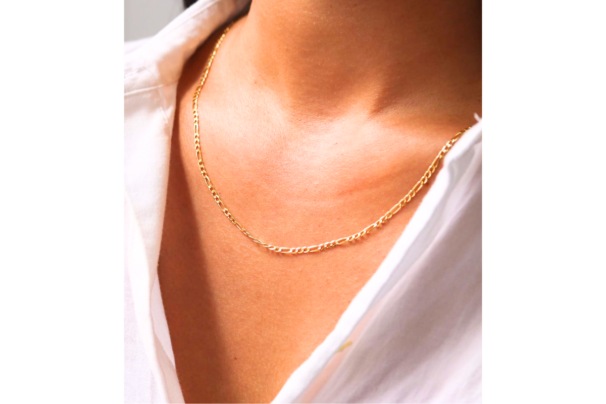 Figaro schakelketting 2,5 mm 14k goud, gedragen om de hals door een model